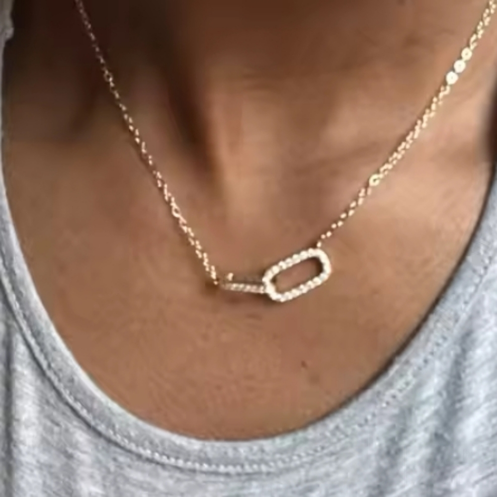 Gold tone necklace with double interlocking zirconia rectangler; nwot